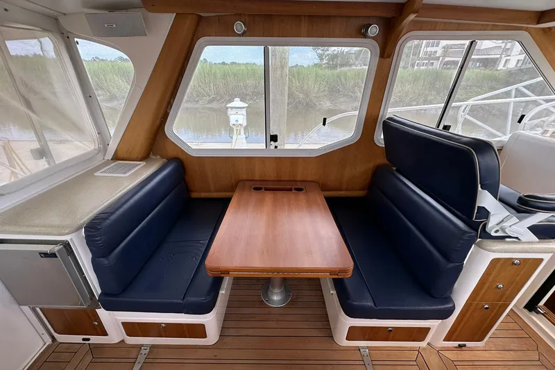 Slide: The Image of Interior of 2007 True North 38 Heritage yacht with blue seating and wooden table. - 58