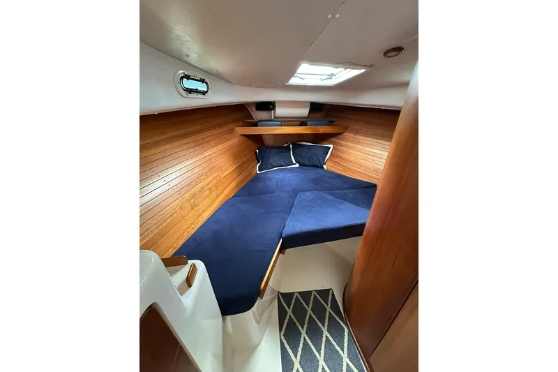 Slide: The Image of Cozy cabin interior of 2007 True North 38 Heritage yacht with wooden paneling and blue bedding. - 80