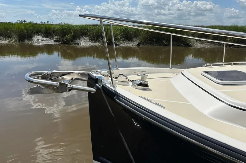 Slide: The Image of Bow of 2007 True North 38 Heritage boat on calm water, with lush greenery background. - 4
