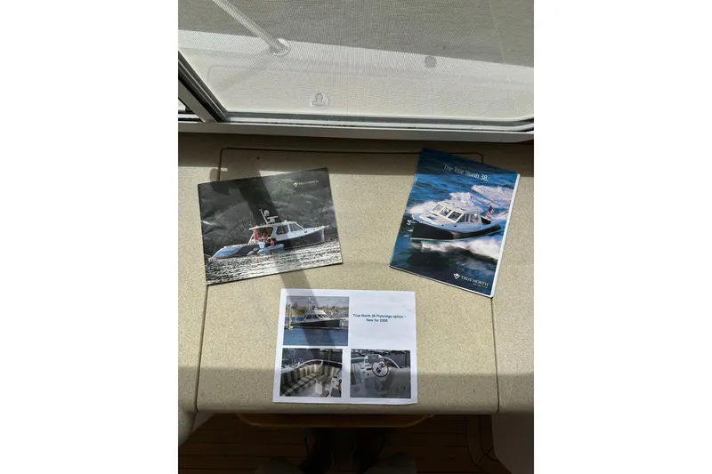Slide: The Image of Brochures of 2007 True North 38 Heritage boat displayed on a table. - 65