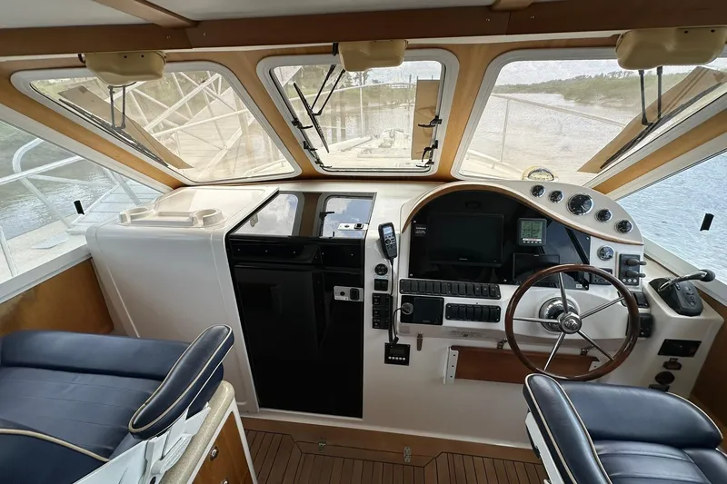 Slide: The Image of Interior view of 2007 True North 38 Heritage boat cockpit with steering wheel and navigation controls. - 113