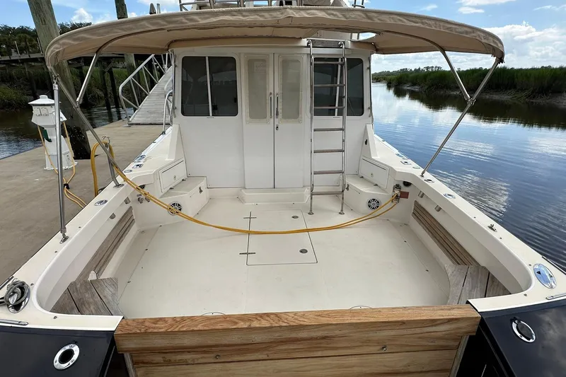 Slide: The Image of 2007 True North 38 Heritage boat with spacious deck and canopy, docked by calm waters. - 17