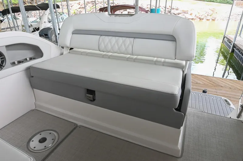 Slide: The Image of 2025 Regal 28 Express boat interior with white cushioned seating and storage compartment. - 15