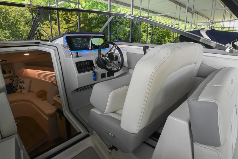 Slide: The Image of 2025 Regal 28 Express boat interior with helm, steering wheel, and cabin view. - 24