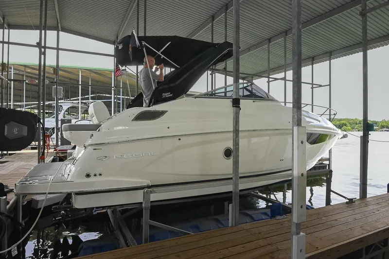 Slide: The Image of 2025 Regal 28 Express boat docked in a covered marina. - 2