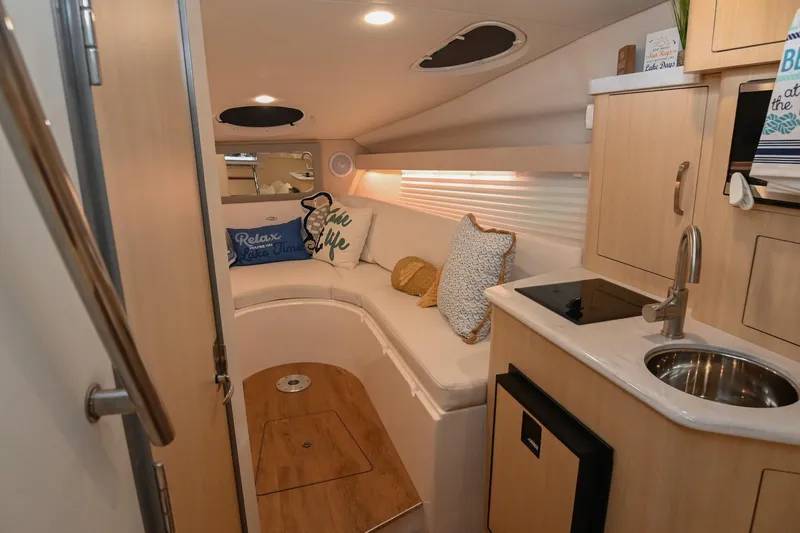 Slide: The Image of Interior of 2025 Regal 28 Express boat with cozy seating and kitchenette. - 36
