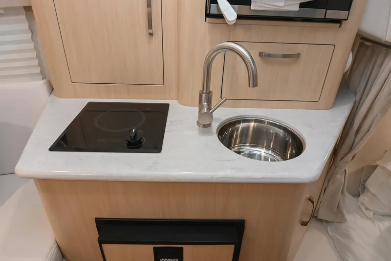 Slide: The Image of Compact kitchen area in 2025 Regal 28 Express boat with sink and stovetop. - 38
