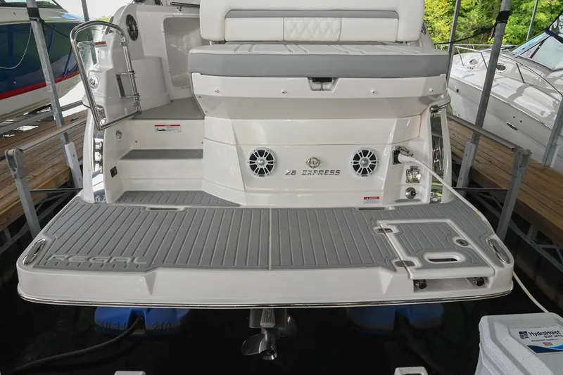 Slide: The Image of 2025 Regal 28 Express boat stern with swim platform and seating area in marina. - 8