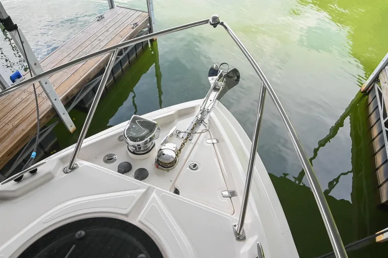 Slide: The Image of Bow of 2025 Regal 28 Express boat docked, featuring anchor and railing. - 34