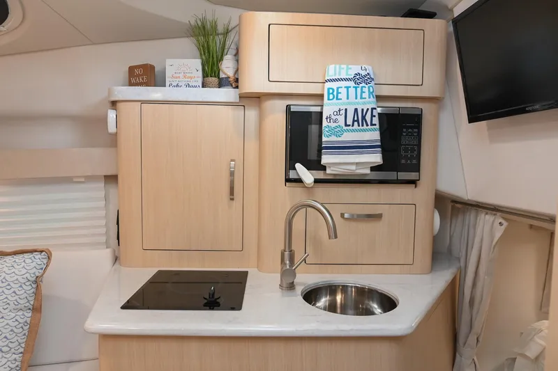 Slide: The Image of Compact kitchen area in a 2025 Regal 28 Express boat with modern amenities. - 37