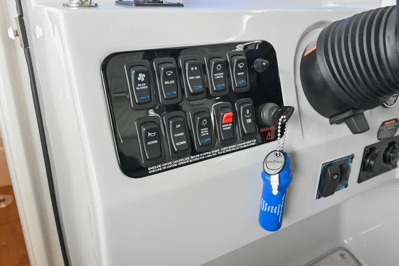 Slide: The Image of Control panel of 2025 Regal 28 Express boat with labeled switches and ignition key. - 29