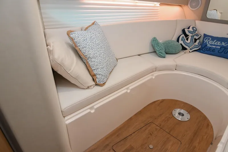 Slide: The Image of Interior of 2025 Regal 28 Express boat with cozy seating and nautical-themed pillows. - 43