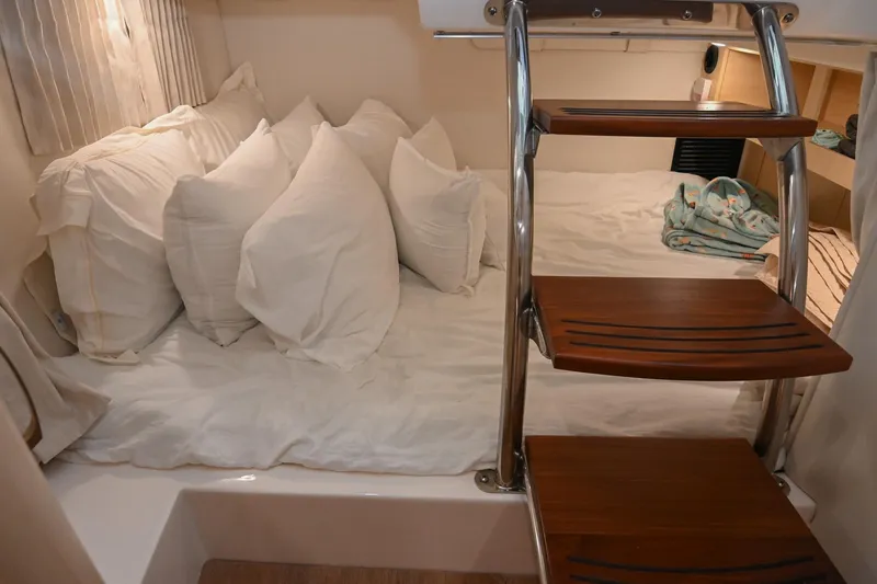 Slide: The Image of Cozy cabin interior of 2025 Regal 28 Express with plush bedding and wooden steps. - 49
