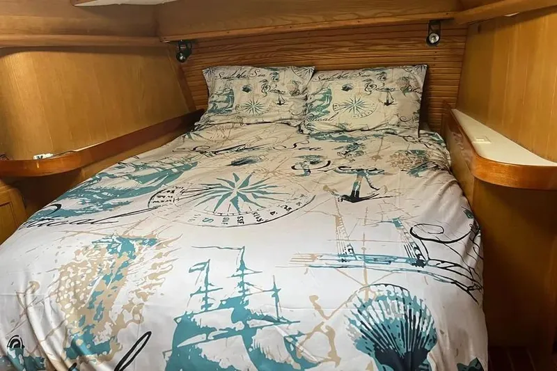 Slide: The Image of Cozy cabin bedroom in a 1995 Freedom 45 CC sailboat with nautical-themed bedding. - 14