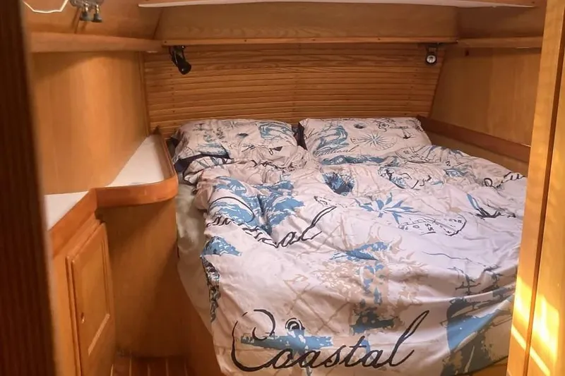Slide: The Image of Cozy cabin bedroom in a 1995 Freedom 45 CC sailboat with nautical-themed bedding. - 13