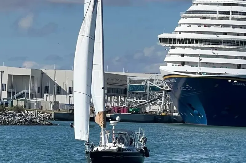 Slide: The Image of Sailboat Freedom 45 CC (1995) near a large cruise ship in a harbor. - 4