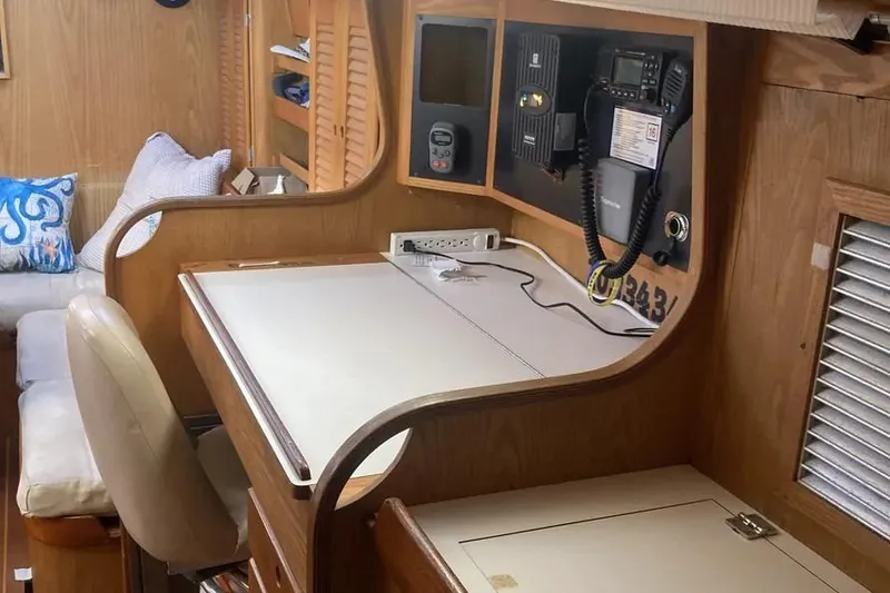 Slide: The Image of Navigation station inside a 1995 Freedom 45 CC sailboat, featuring communication equipment and a comfortable seating area. - 12