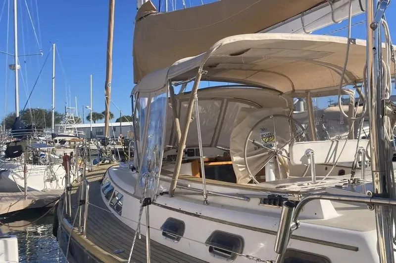 Slide: The Image of Sailboat docked at marina, Freedom 45 CC, 1995 model, with beige canopy and clear skies. - 5