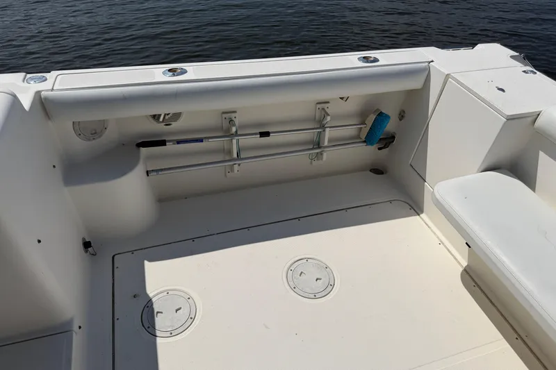 Slide: The Image of 1998 Pursuit 2860 Denali boat deck with storage compartments and cleaning tools. - 7