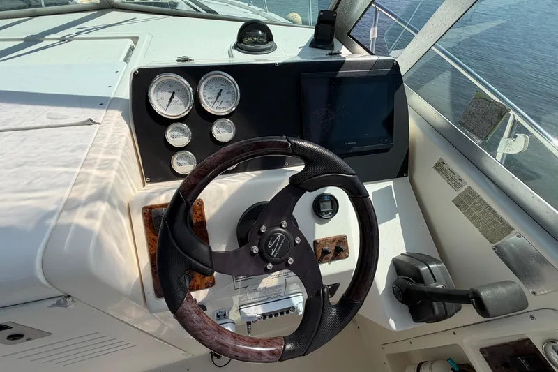 Slide: The Image of Steering wheel and dashboard of a 1998 Pursuit 2860 Denali boat, featuring gauges and controls. - 10