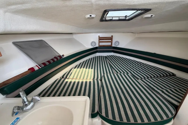 Slide: The Image of Interior cabin of 1998 Pursuit 2860 Denali boat with striped cushions and sink. - 11