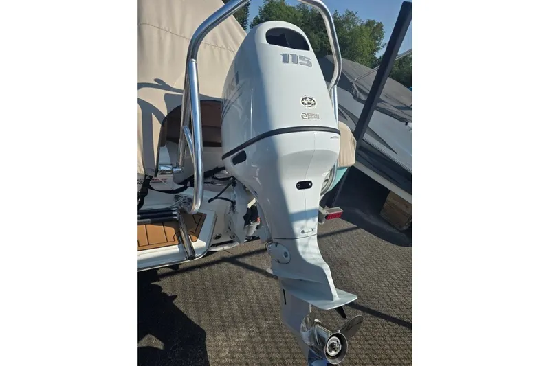 Slide: The Image of Outboard motor on a 2023 Pioneer 180 Islander boat, parked outdoors. - 8