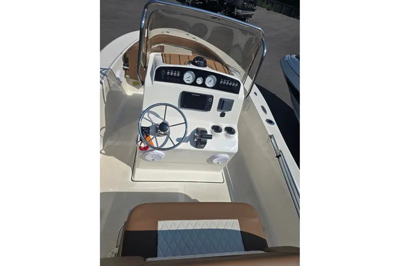 Slide: The Image of 2023 Pioneer 180 Islander boat dashboard with steering wheel and controls. - 5