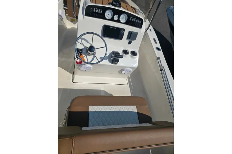 Slide: The Image of 2023 Pioneer 180 Islander boat dashboard with steering wheel and gauges. - 8