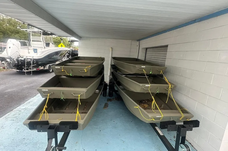 Slide: The Image of Stacked 2025 White River 1436 Topper boats under a covered area. - 10