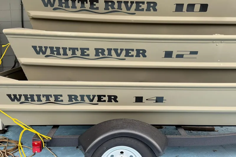 Slide: The Image of Stacked White River boats on trailer, showcasing models 10, 12, and 14. - 9