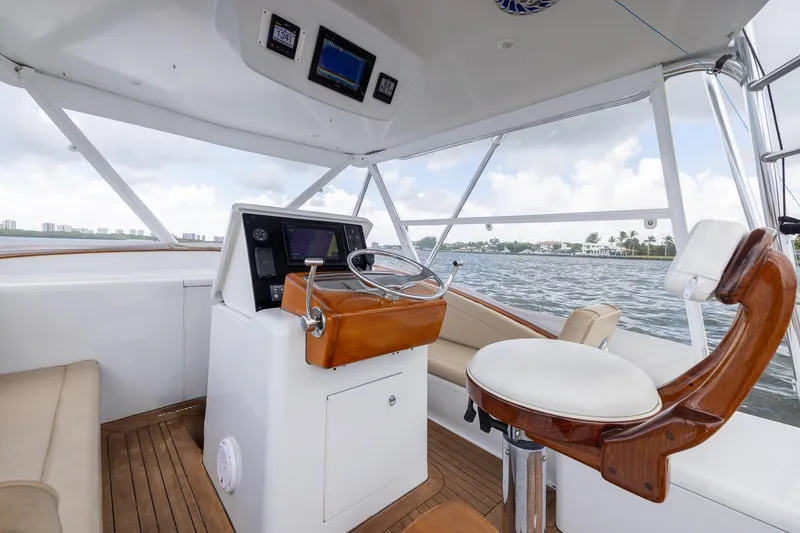 Slide: The Image of Helm of 2001 Predator Express boat with wooden accents and modern navigation equipment. - 21