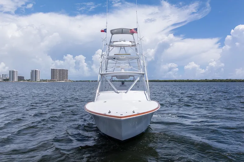 Slide: The Image of 2001 Predator Express boat on open water with city skyline and cloudy sky. - 2