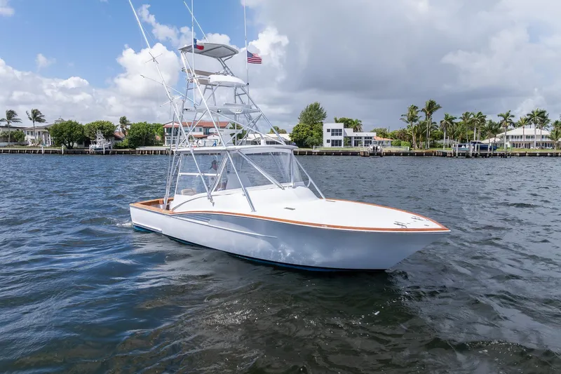 Slide: The Image of 2001 Predator Express boat on water, with coastal homes and palm trees in the background. - 39