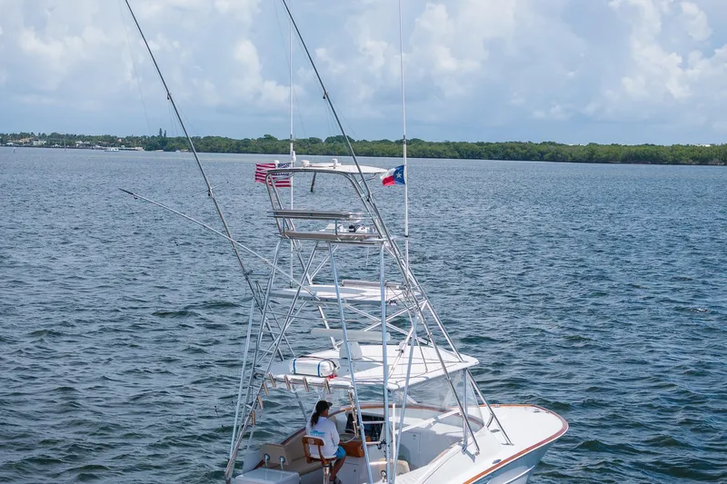 Slide: The Image of 2001 Predator Express boat on open water with flags, under a cloudy sky. - 43