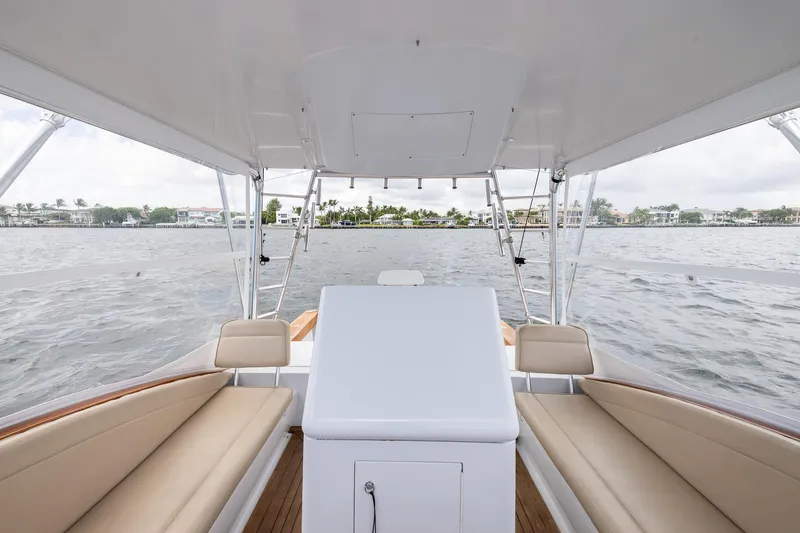 Slide: The Image of 2001 Predator Express boat interior with beige seating, overlooking a scenic waterfront view. - 19