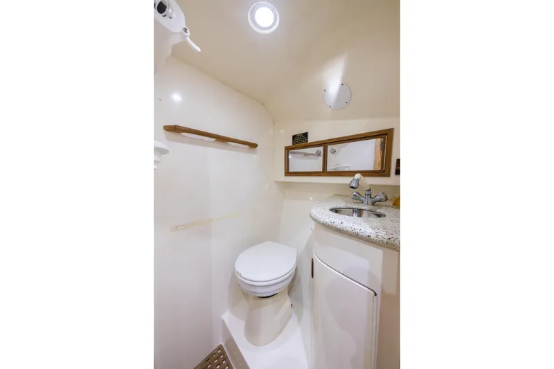 Slide: The Image of Compact boat bathroom with toilet, sink, and mirror in 2001 Predator Express model. - 34