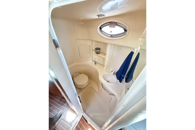Slide: The Image of Compact bathroom in 2005 Sea Ray 300 Sundancer boat with toilet, sink, and porthole. - 12