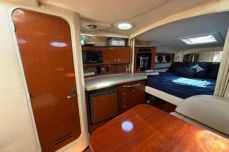 Slide: The Image of Interior of 2005 Sea Ray 300 Sundancer yacht with kitchenette and cozy sleeping area. - 11