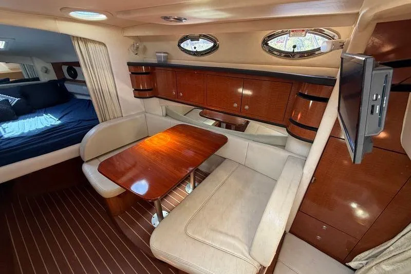 Slide: The Image of Interior of 2005 Sea Ray 300 Sundancer with dining area and cozy cabin. - 10