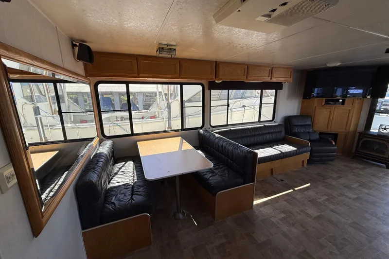 Slide: The Image of Interior of a 1998 Patio Cruiser 55 houseboat with seating and windows. - 16