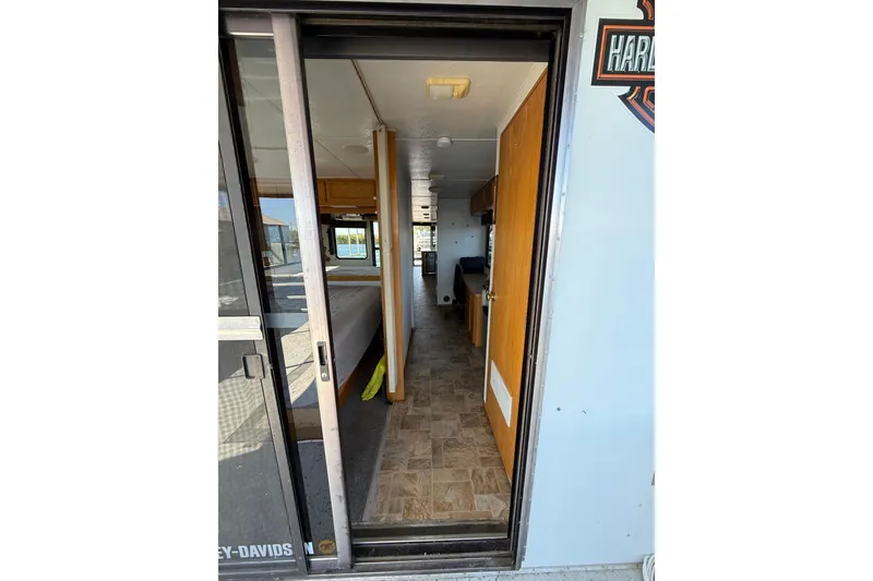 Slide: The Image of Interior view of a 1998 Patio Cruiser 55 RV with wood paneling and tiled flooring. - 21