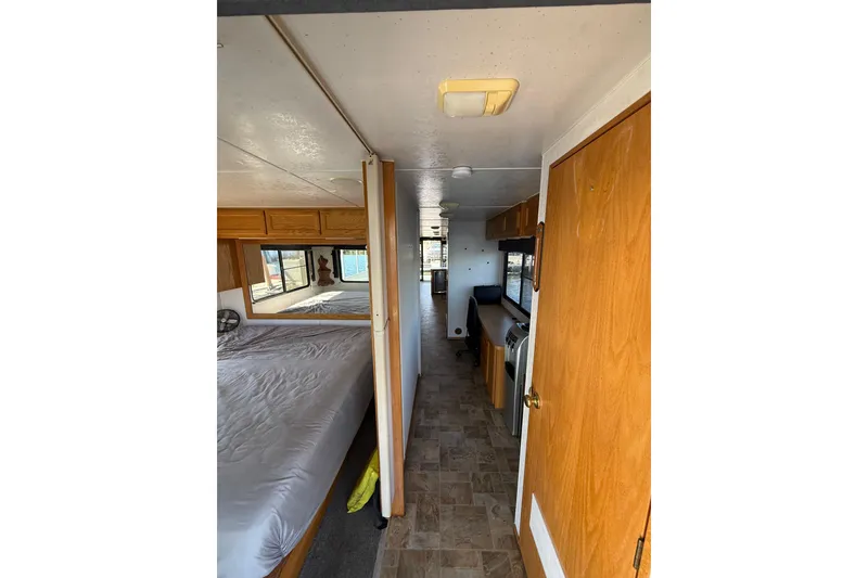 Slide: The Image of Interior of a 1998 Patio Cruiser 55 houseboat with bedroom and kitchen area. - 20