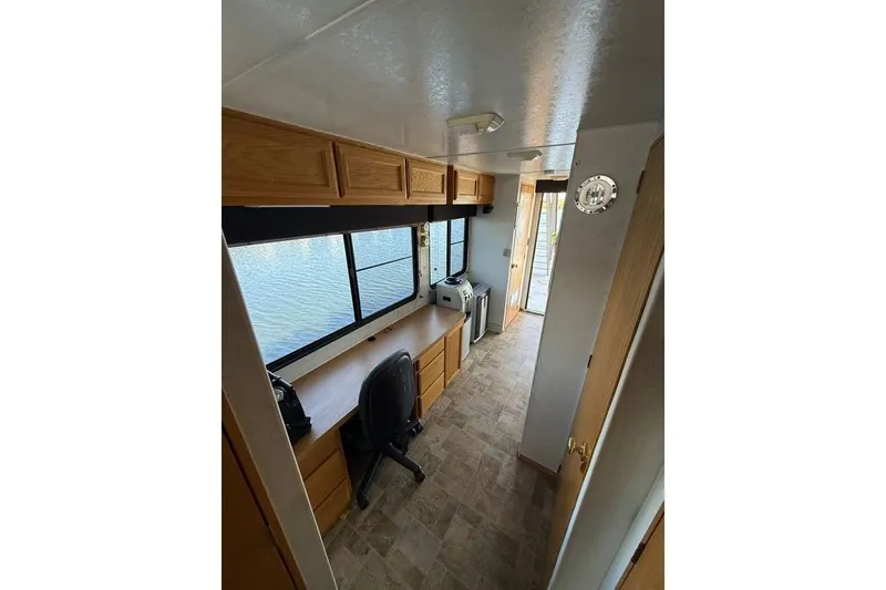 Slide: The Image of Interior of 1998 Patio Cruiser 55 houseboat with desk, chair, and large windows. - 19