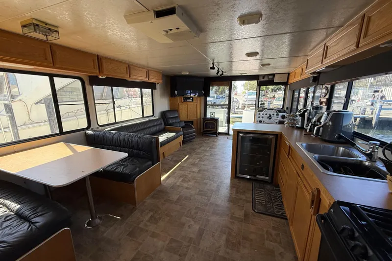 Slide: The Image of Interior of a 1998 Patio Cruiser 55 houseboat with kitchen and seating area. - 15