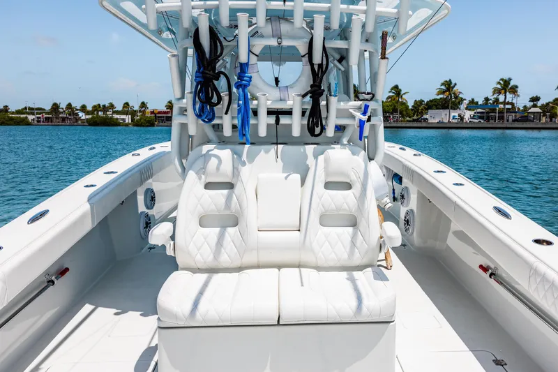 Slide: The Image of 2024 Freeman 34VH boat interior with white seating, rod holders, and ocean backdrop. - 31