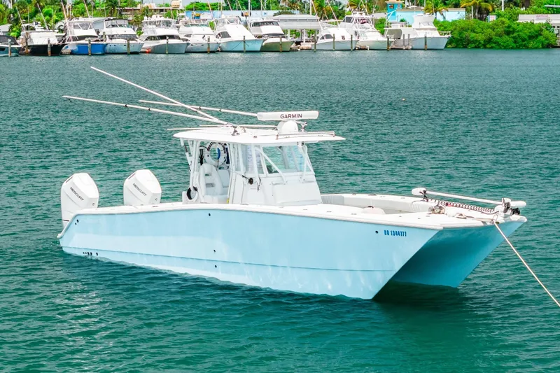 Slide: The Image of 2024 Freeman 34VH boat on water, featuring dual Mercury engines, docked near marina. - 43