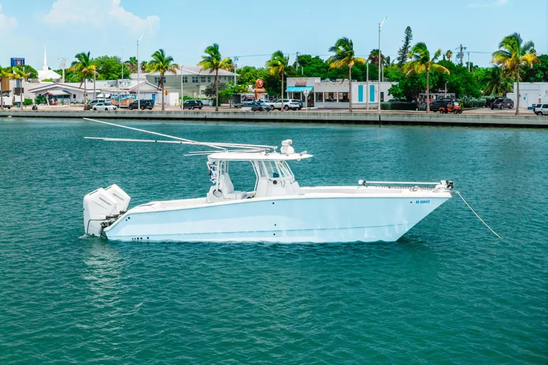 Slide: The Image of 2024 Freeman 34VH boat anchored in a tropical marina with palm trees and buildings. - 42