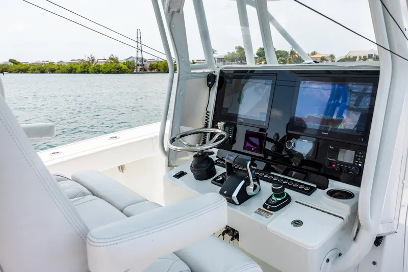 Slide: The Image of 2024 Freeman 34VH boat helm with advanced navigation displays and controls on a serene waterway. - 36