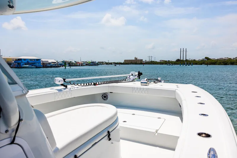 Slide: The Image of 2024 Freeman 34VH boat on calm waters with coastal buildings in the background. - 16