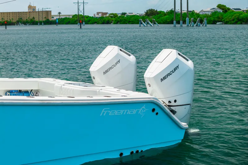 Slide: The Image of 2024 Freeman 34VH boat with dual Mercury outboard engines on a calm waterway. - 41